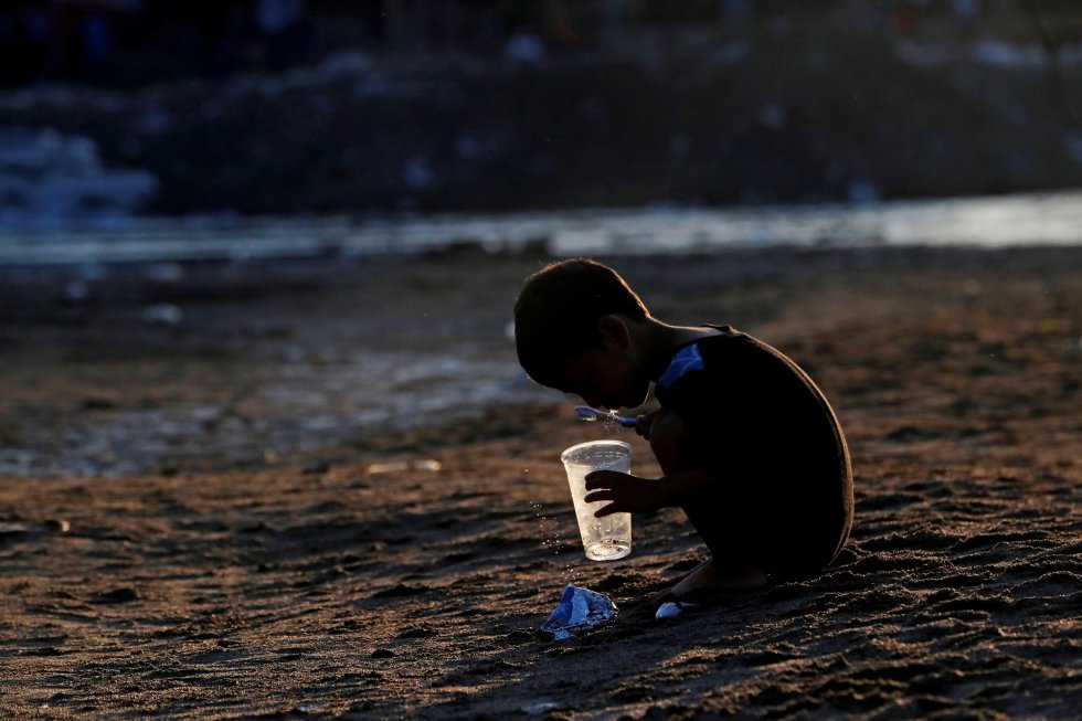 Un niño hondureño se cepilla los dientes en Tecún Umán (Guatemala). Cientos de migrantes cruzaron el río Suchiate, que separa Guatemala de México, a fin de entrar en territorio mexicano ilegalmente.