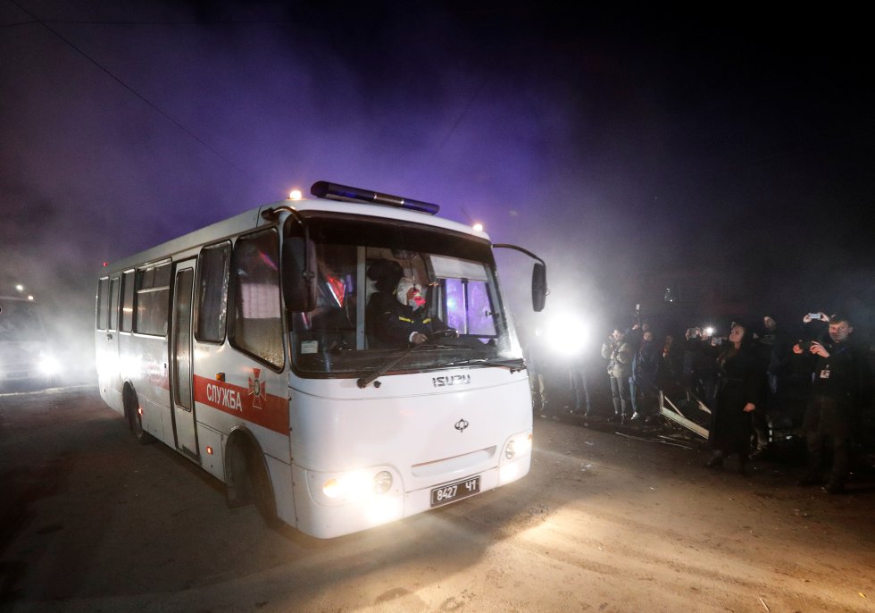 Uno de los autobuses que trasladaba a los evacuados de la provincia de Hubei llega a Novye Sanzhari rodeado de manifestantes.
