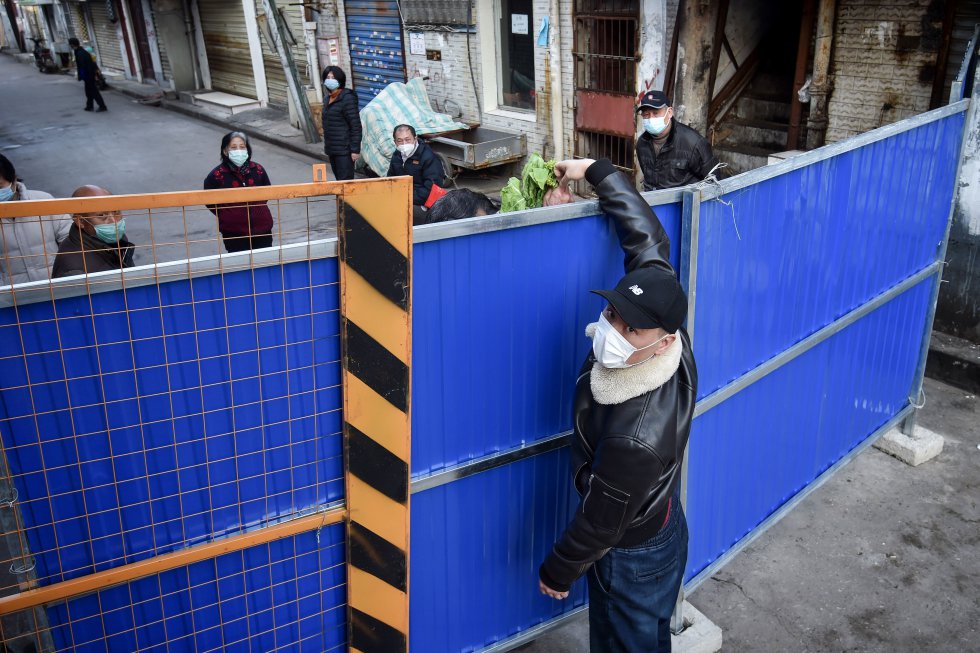 Um homem entrega comida em um bairro isolado na cidade chinesa de Wuhan, epicentro do surto, em 23 de fevereiro.