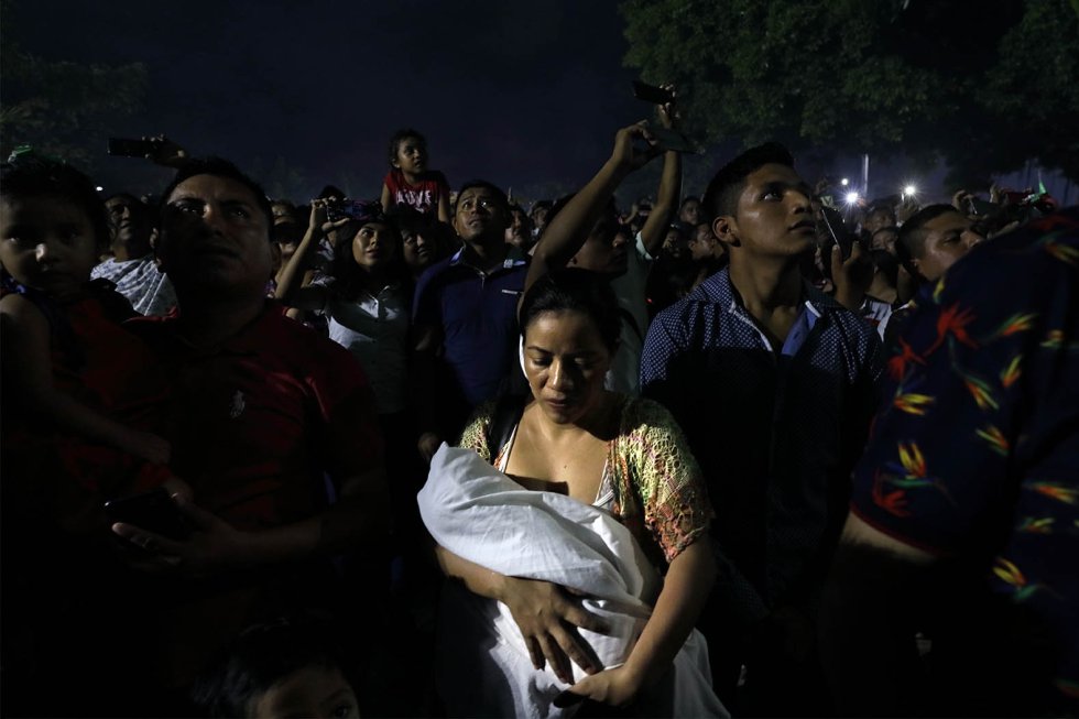 Una mujer sostiene a su bebé después de discutir con su esposo mientras su familia disfruta de los fuegos artificiales durante la celebración del día de la Independencia de México en la plaza principal del municipio Benito Juárez, en Cancún.rn