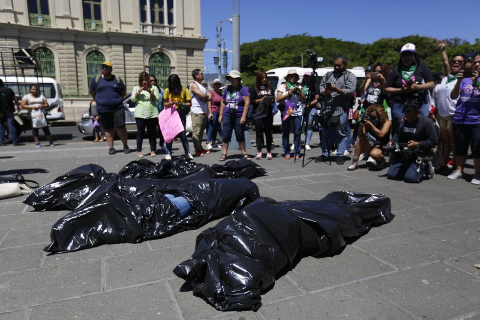 En San Salvador las mujeres escenificaron cadáveres falsos en bolsas para protestar en contra de los feminicidios en el país centroamericano.