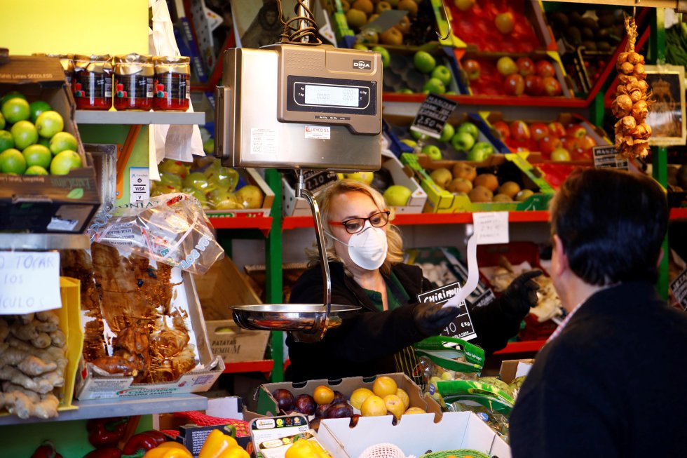 Una vendedora, protegida con mascarilla, trabaja en su puesto del mercado de abastos, este sábado, en Córdoba.