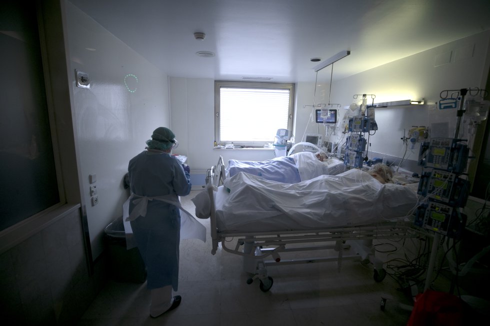 Una empleada de limpieza en una de las habitaciones de una UCI en la que hay dos pacientes entubados afectados por covid-19.