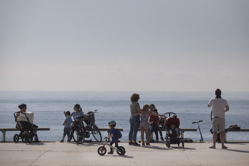 Niños y padres disfrutan del paseo marítimo de Barcelona.