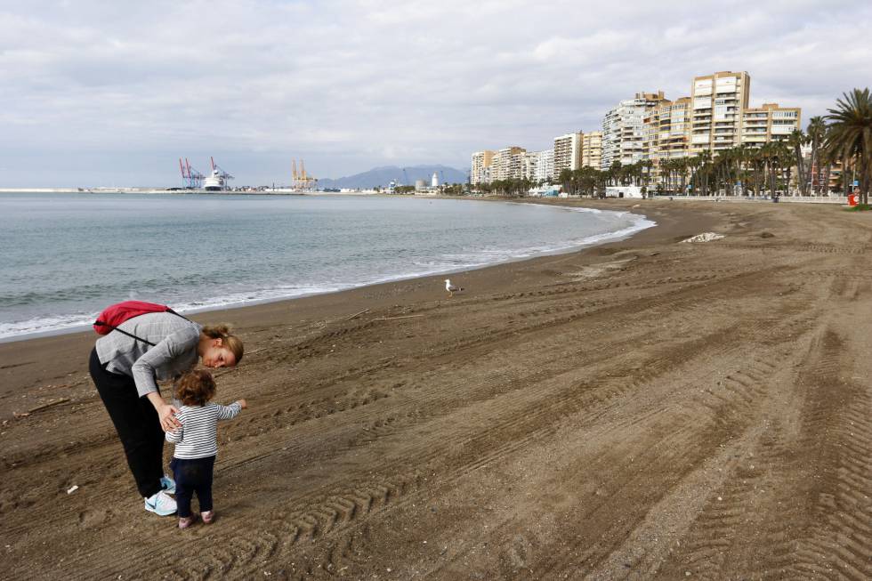 Una mujer con su hijo en la playa de La Malagueta, en Málaga.