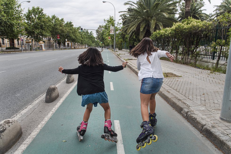 Dos niñas patinan en una calle de Sevilla.