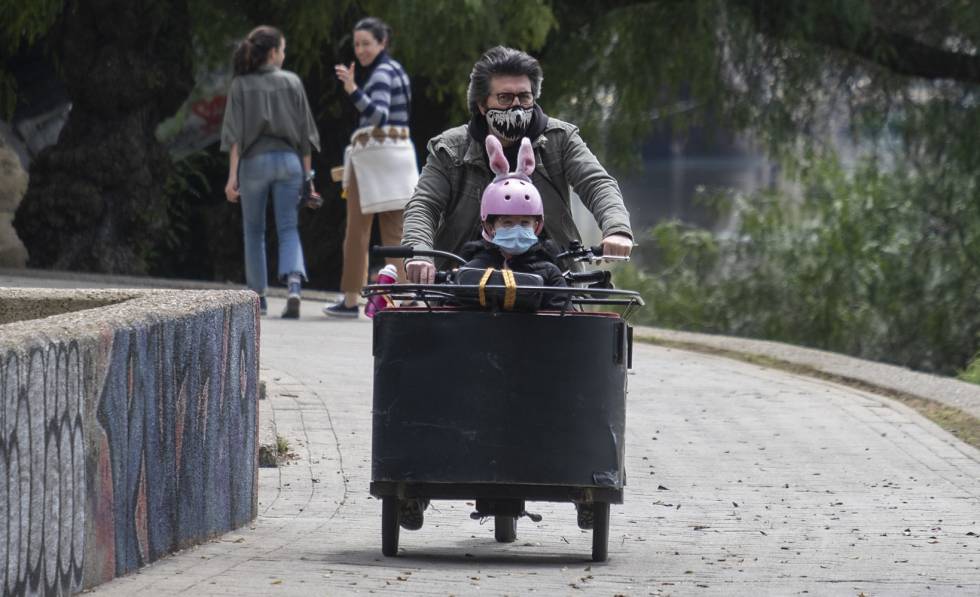 Un padre pasea en bicicleta con su hija en Sevilla.