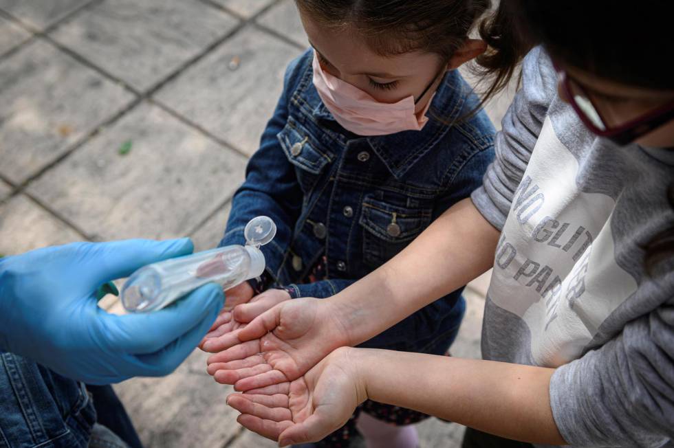 Dos niños se desinfectan las manos en Meco (Madrid).