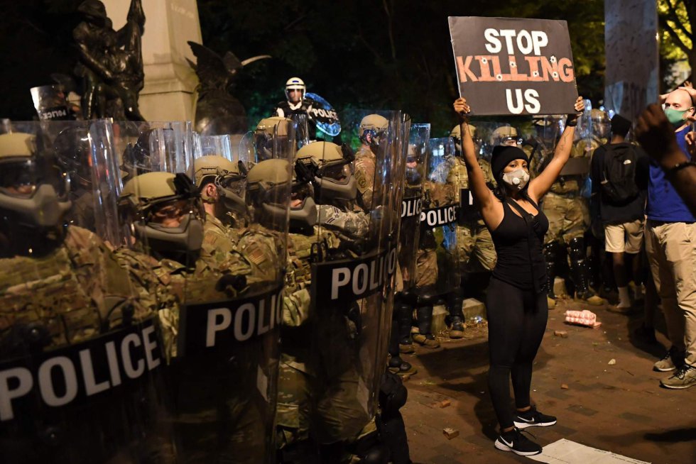 En Los Ángeles, en la noche del viernes, una pequeña protesta que apenas ocupó cuatro calles del centro había provocado amplios destrozos en comercios y se había saldado con 533 detenidos y seis policías heridos. A media tarde era evidente que la protesta de este sábado, esta vez en varios puntos de la ciudad, era más numerosa y violenta aún. En la imagen, una joven sostiene una pancarta durante una protesta frente a la Casa Blanca.