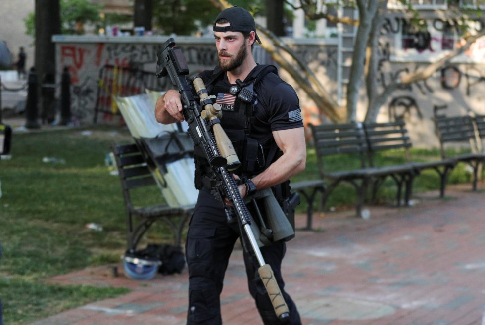 Un miembro del servicio secreto estadounidense sostiene un rifle tipo 'sniper' durante el cordón policial establecido para que Trump acudiese a la iglesia de Saint John's en un acto para condenar los disturbios.