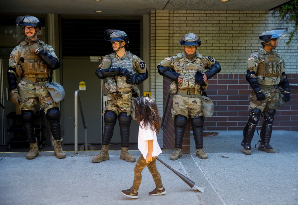 Un niña pasa frente a varios miembros de la Guardia Nacional, en Washington. 