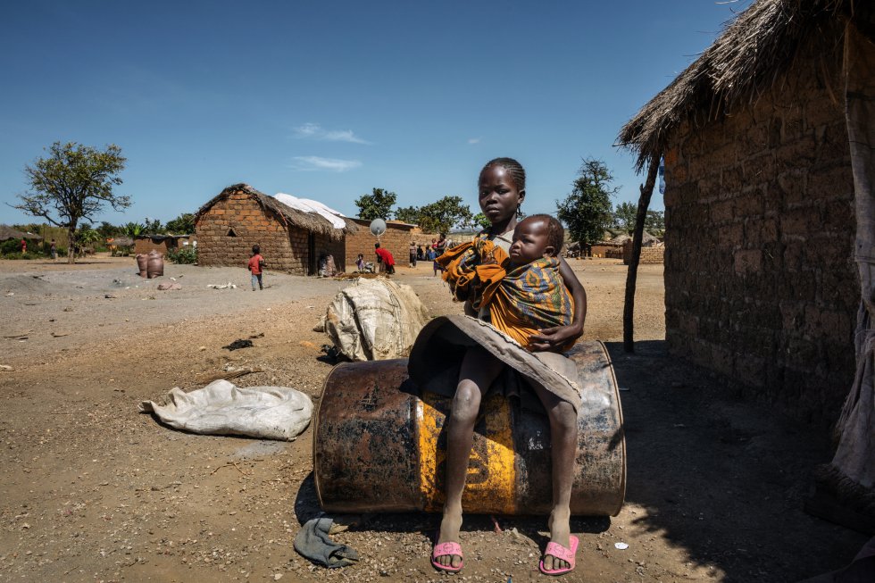 Makila Mgoj, de 14 años, cuida de su hermano pequeño mientras sus padres trabajan en la mina.