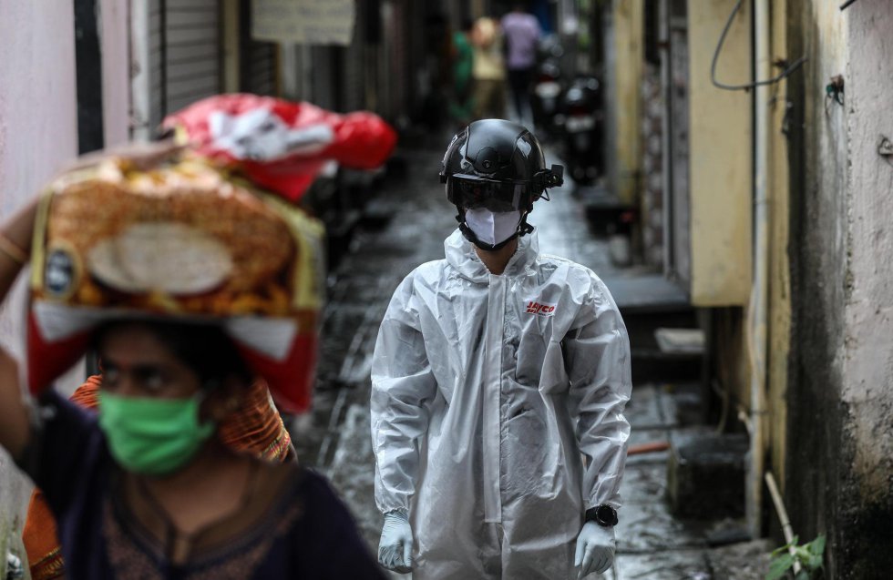 Un sanitario camina por una calle tras tomar muestras para pruebas de coronavirus a varios residentes en una zona de chabolas en Bombay (India). India es ya el tercer país del mundo con más casos de coronavirus.