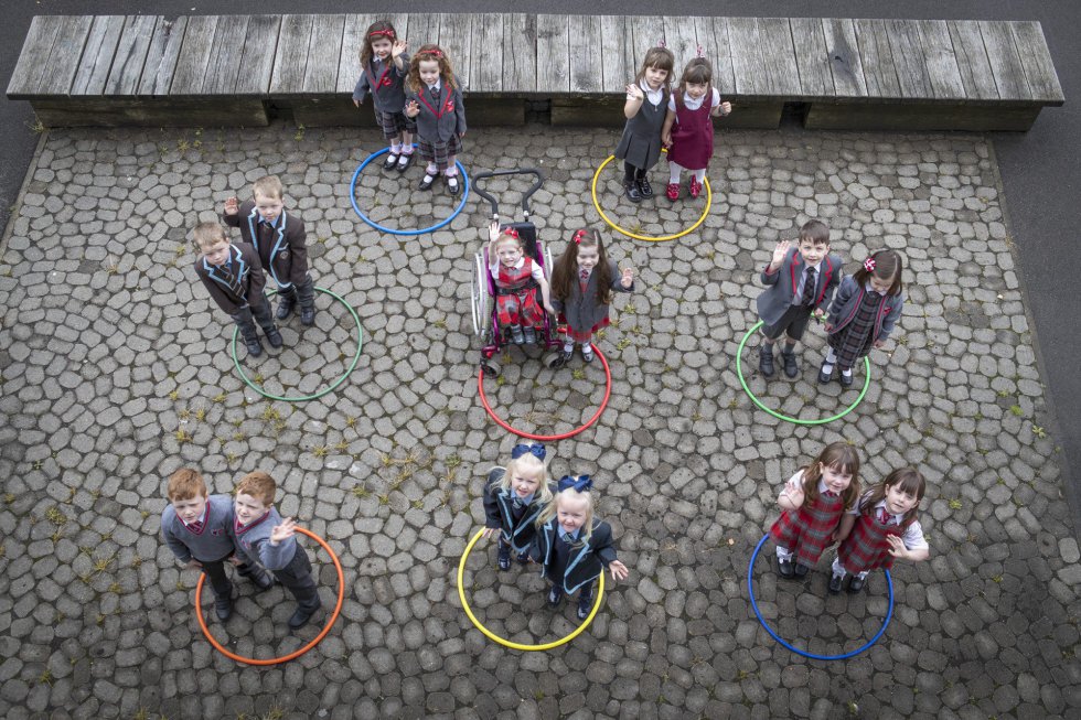 Varios grupos de niños posan en su primer día de clases tras la vuelta al colegio, en la escuela de primaria Newark, Glasgow (Escocia).