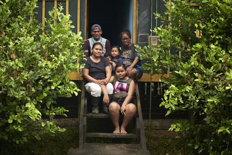 Lilia Isolina Java Tapayuri posa para un retrato junto a su esposo Aldo, sus hijas Ainara y Michel y su madre Tapayuri, frente a su casa en la comunidad colombiana de San Francisco, a pocas millas al noroeste de Puerto Nariño, sobre el río Loretoyacu, afluente del Amazonas. La vivienda se encuentra vacía debido a que la familia reside en la Fundación donde Lilia trabaja. Para esta líder comunitaria de la etnia cocama, en el resguardo Tikuna-Cocama-Yagua, el delfín rosado es sagrado. Y ocupa una parte central en su trayecto vital y profesional que la ha llevado a ocupar hoy un papel importante en la conservación de la fauna fluvial de este rincón de la selva amazónica.