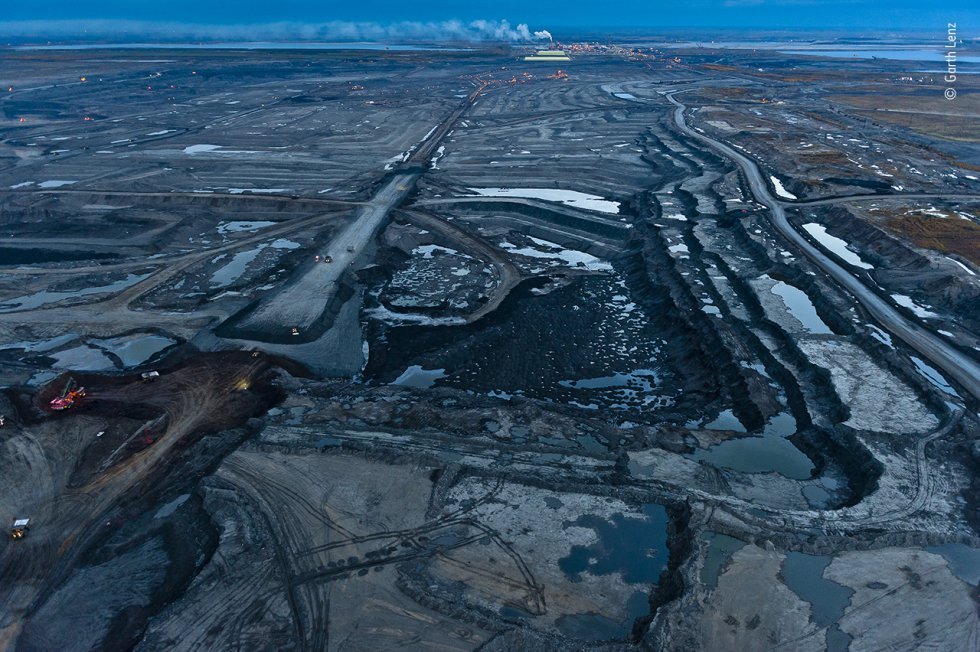 A medida que cae el crepúsculo sobre las arenas bituminosas de Alberta (Canadá), el paisaje adquiere un tinte azul. Esta vasta extensión, que alguna vez fue un bosque boreal, es solo una sección de la mina de arenas bituminosas de Mildred Lake, solo una de las muchas minas de la región que conforman la tercera reserva de petróleo más grande del mundo.