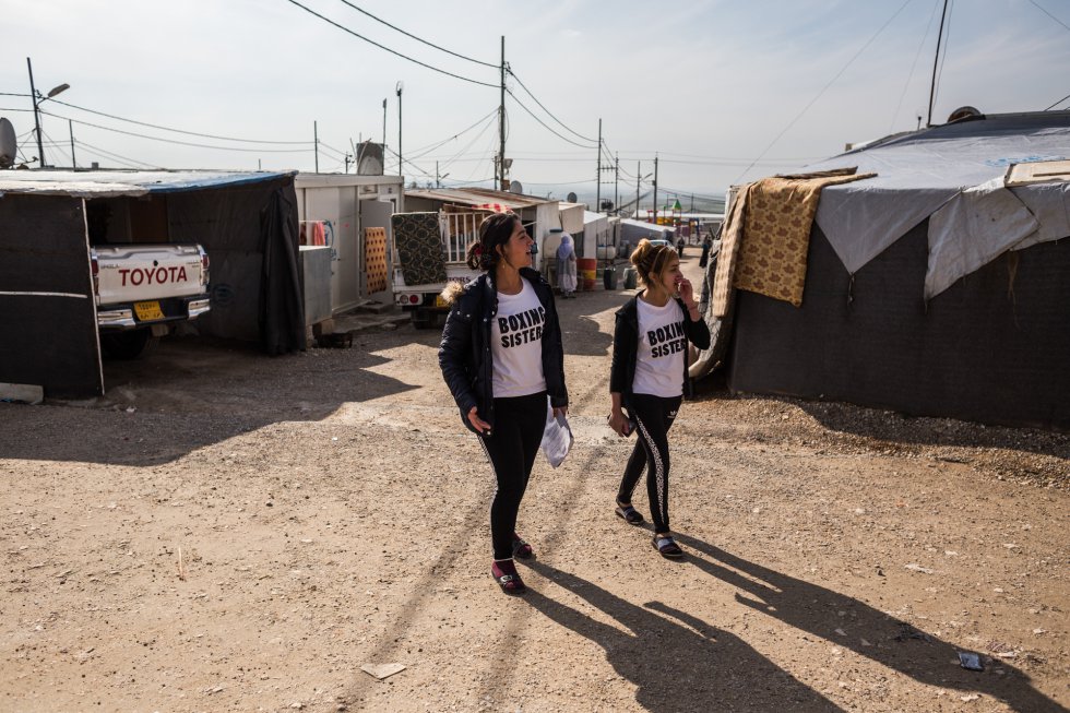 Husna camina con una amiga por una de las calles del campo de refugiados de Rwanga, donde ha estado viviendo desde que escapó del ISIS en 2014. Cathy Brown, campeona de boxeo femenino, se involucró en el proyecto desde sus comienzos. La deportista visitó el campamento y entrenó a Husna y a otras chicas yazidíes durante 10 días.