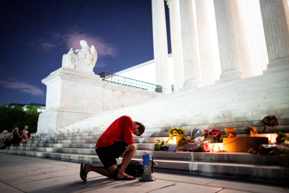 Un hombre se arrodilla durante un homenaje improvisado en los escalones del Tribunal Supremo de Estados Unidos en Washington (EE UU).