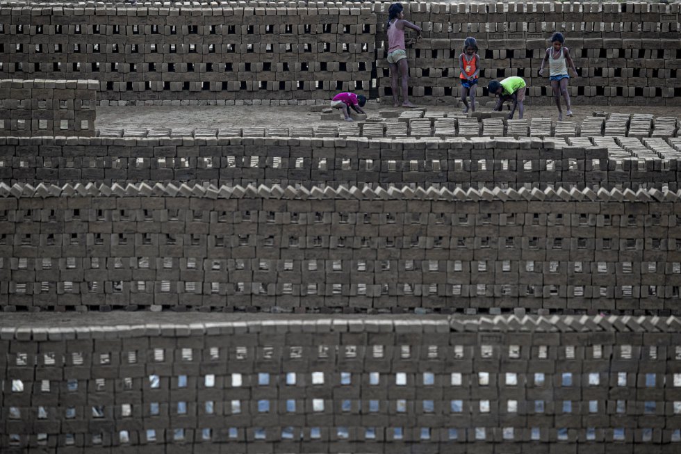 Un grupo de niños trabajan en un horno de ladrillos en las afueras de Gauhati (India). El país se acerca a los 8,6 millones de contagios de coronavirus, tras registrar 38.074 casos en las últimas 24 horas, tal y como ha informado el Ministerio de Salud en la actualización diaria de las cifras del virus en el país.