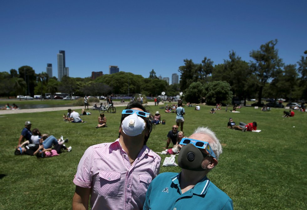La televisión transmitió en directo y en todas las ciudades hubo postales de ciudadanos mirando con gafas hacia el cielo. En imagen, grupos de personas se reunieron para ver el eclipse desde un parque en Buenos Aires, Argentina.