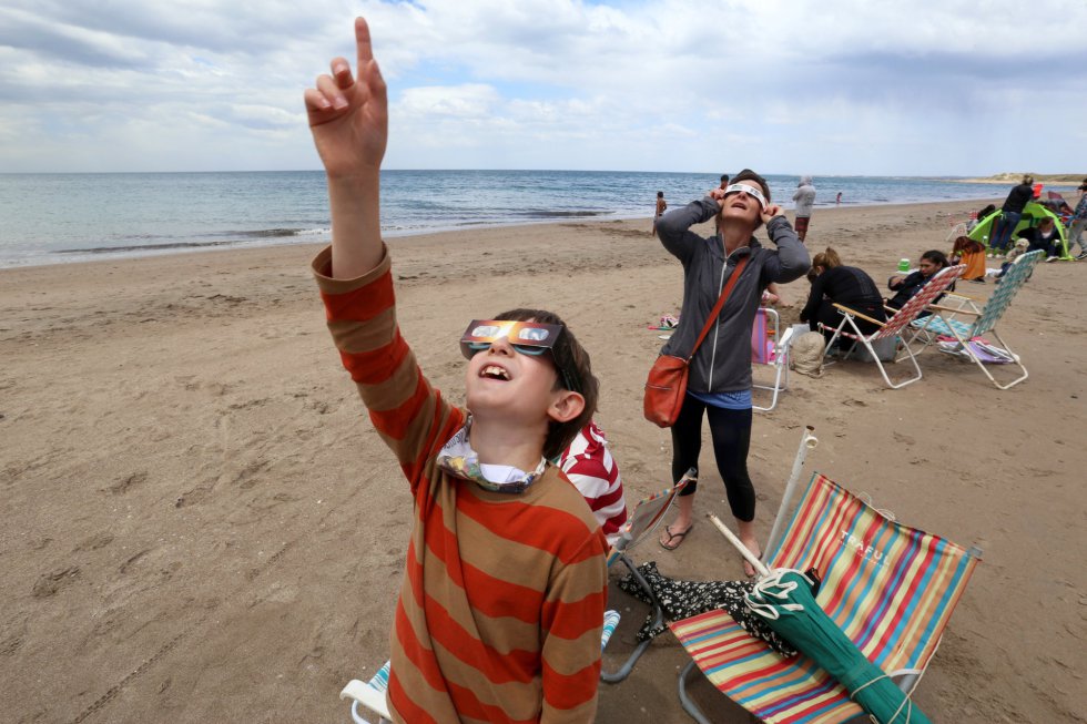 Una familia observa el eclipse en Las Grutas, Argentina.