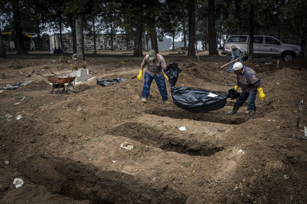 Trabalhadores de cemitérios na Cidade da Guatemala enterram vários corpos não identificados.  Cada semana eles recebem entre cinco e dez cadáveres anônimos.