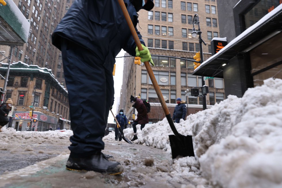 La tormenta ha obligado a que se cancelen vuelos en la costa este de los Estados Unidos. En la imagen, trabajadores limpian la nieve en las calles de Manhattan.