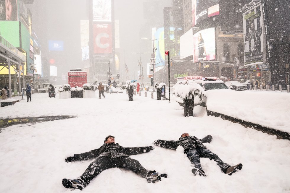 Dos hombres hacen ángeles de nieve en Times Square.