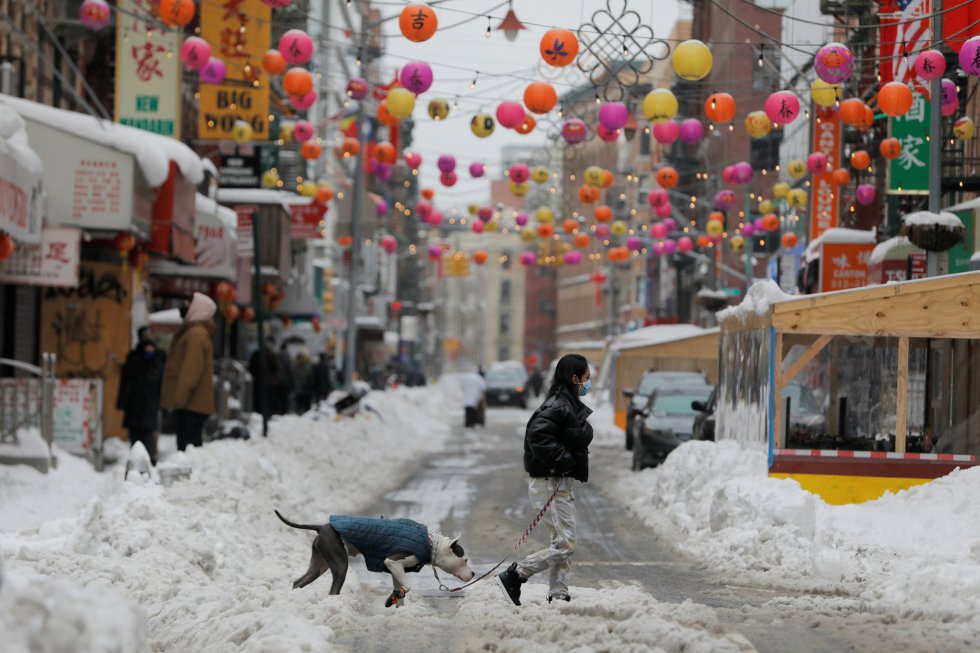 Una mujer pasea por Chinatown después de la nevada.
