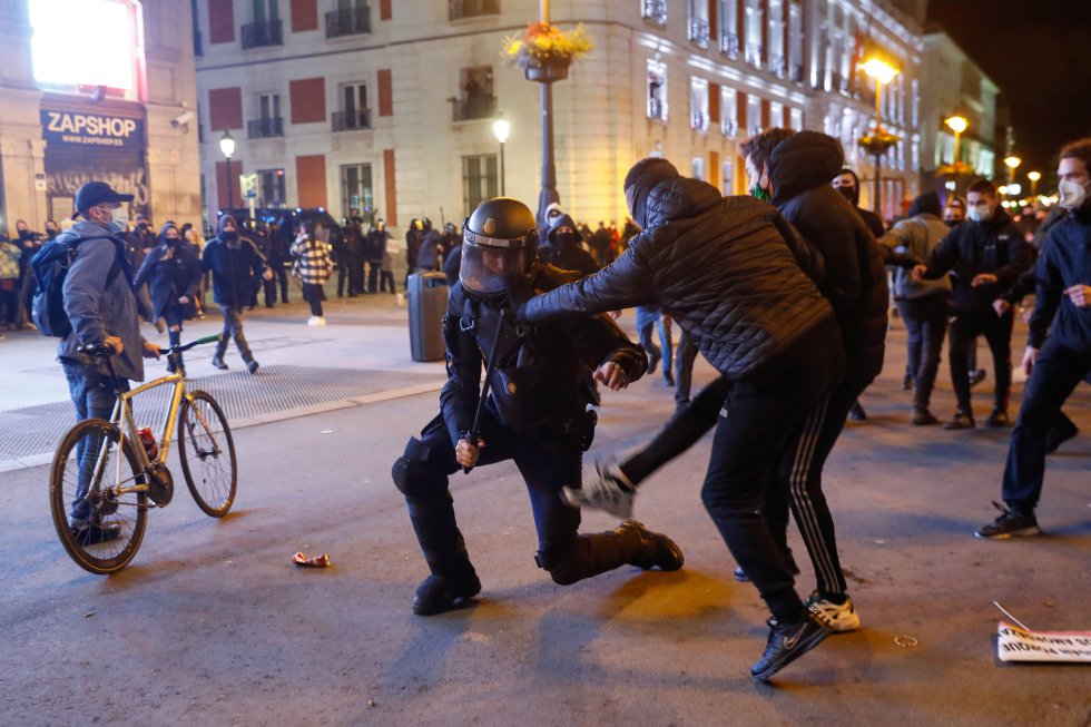 Des centaines de personnes se sont rassemblées ce mercredi dans le centre de Madrid pour exiger la libération du rappeur Pablo Hasél, arrêté ce mardi à Lleida pour purger la peine prononcée par la Haute Cour nationale pour un crime de glorification du terrorisme et des insultes et calomnies contre la monarchie et les forces de sécurité de l'État après avoir diffusé des messages menaçants sur les réseaux sociaux.  Dans l'image, deux manifestants font face à un policier.