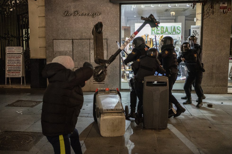 Un manifestant lance une planche à roulettes sur un groupe de policiers anti-émeute dans une rue du centre de Madrid.