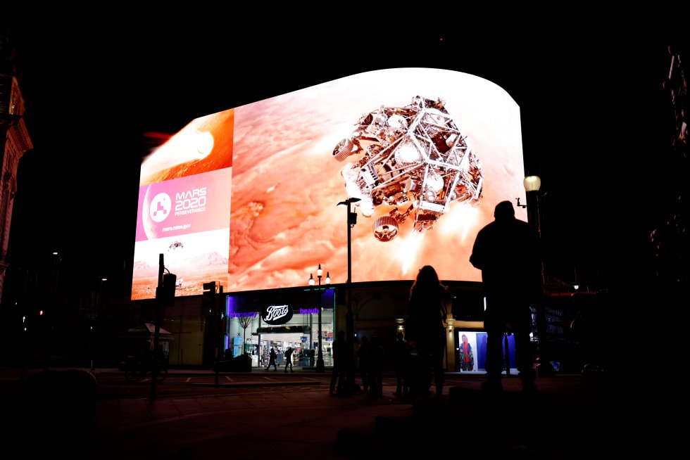 Varias personas siguen la retransmisión del aterrizaje del vehículo de exploración ‘Perseverance’ a Marte, en una pantalla gigante de Picadilly Circus, en Londres (Inglaterra).