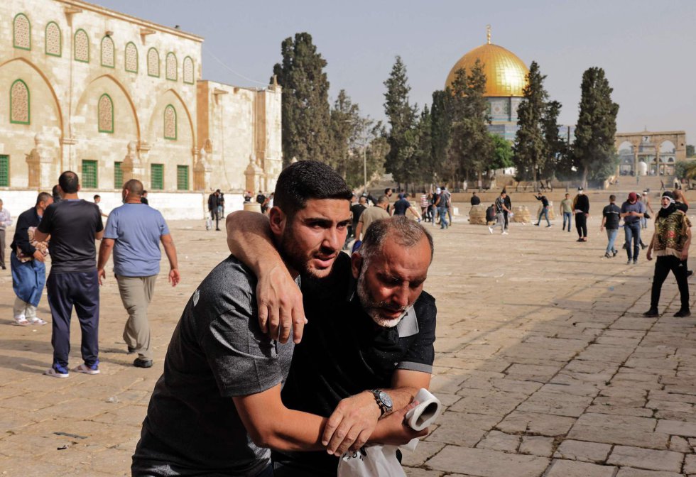 Un palestino ayuda a un manifestante herido en medio de los enfrentamientos en la mezquita Al Aqsa, este lunes. Los enfrentamientos con agentes de la policía israelí comenzaron por la mañana y acabaron con "215 heridos", según informó el servicio de emergencias Media Luna Roja, que concretó que más de 153 tuvieron que ser evacuados a hospitales de la ciudad o trasladados a su clínica de campaña.