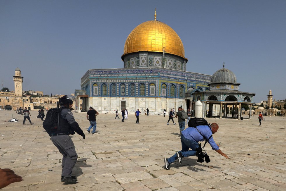 Un operador de cámara cae al suelo durante los enfrentamientos en el complejo que alberga la mezquita Al Aqsa, este lunes.