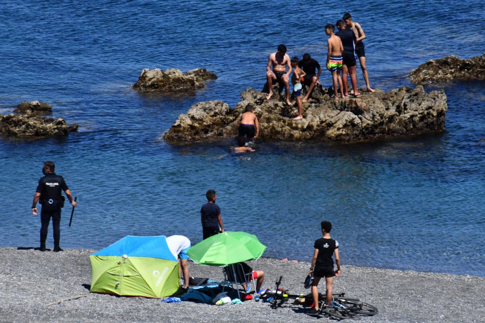Os efetivos policiais não deram abasto e mais de uma centena de jovens entraram em Ceuta pela zona do Tarajal sem problemas. Na imagem, um agente da policial local vigia vários imigrantes, na segunda-feira.