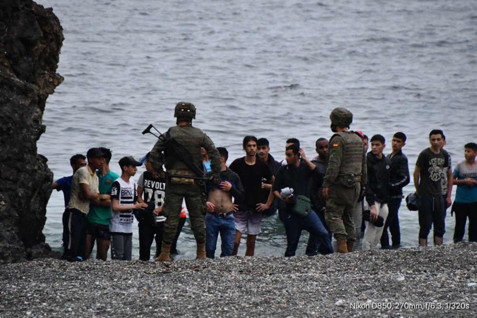 Militares controlam um grupo de imigrantes que chegaram a nado nos quebra-mares da fronteira de Ceuta, nesta terça-feira. Nas últimas 24 horas, milhares de jovens, mas também famílias inteiras, se lançaram ao mar ante a passividade das autoridades marroquinas. Entre os recém-chegados calcula-se que há cerca de 1.500 menores de idade. Um homem morreu na tentativa.
