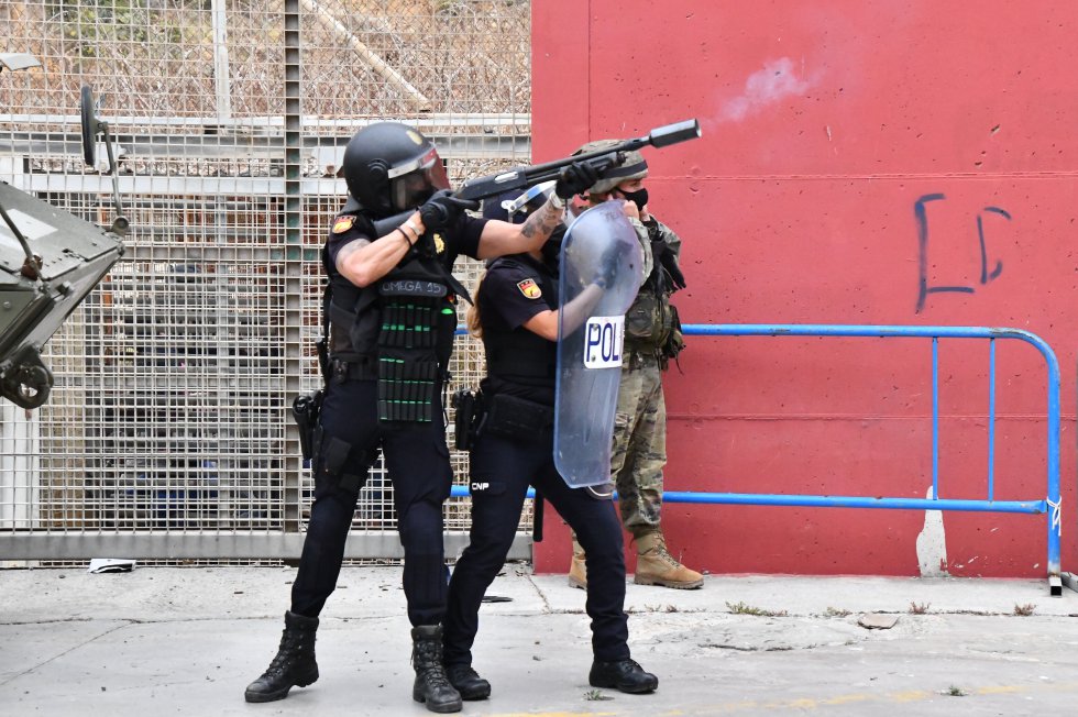Um agente da Policial Nacional lança bombas de fumaça no perímetro da cidade de Ceuta, nesta terça-feira.