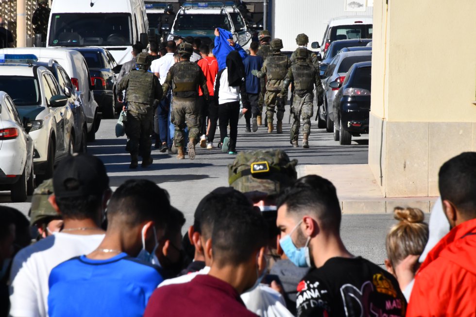 Un grupo de menores es trasladado desde una de las naves del polígono del Tarajal. Estas naves fueron utilizadas para los marroquíes mayores de edad durante la pandemia, y ahora están siendo utilizadas para los más jóvenes. 