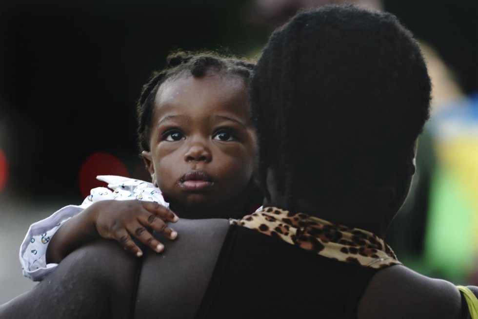 Un migrante haitiano con un bebé camina por la carretera en Huixtla,Chiapas. 