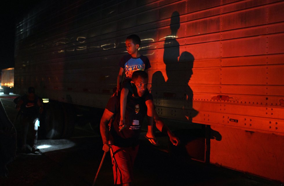 Un migrante viaja con un niño en sus hombros en Macastepec, Chiapas. Pese a ser calificados despectivamente como “sin papeles”, miles de migrantes acarrean carpetas completas con sus expedientes e historias de vida para presentar a las autoridades migratorias primero y después, a la Comisión Mexicana de Ayuda al Refugiado (COMAR).