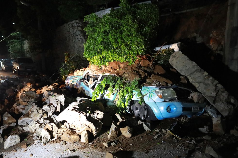 Un vehículo sepultado tras derrumbarse un muro en Acapulco. El gobernador de Guerrero, Héctor Astudillo, informó que una persona falleció en el municipio de Coyuca de Benítez tras ser aplastada por un poste que se cayó a causa del seísmo.