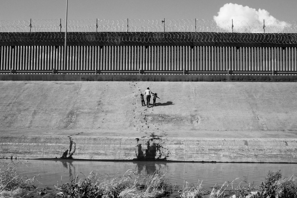 Dos niños y una mujer acceden a Estados Unidos en los alrededores de Ciudad Juárez (México).   En 2021 viajé a Honduras después de que los huracanes Eta e Iota azotaran Centroamérica. Allí, las inundaciones ylos deslizamientos de tierra afectaron a 4,5 millones de víctimas y alimentaron una de las migraciones más importantes de la última década hacia Estados Unidos.   