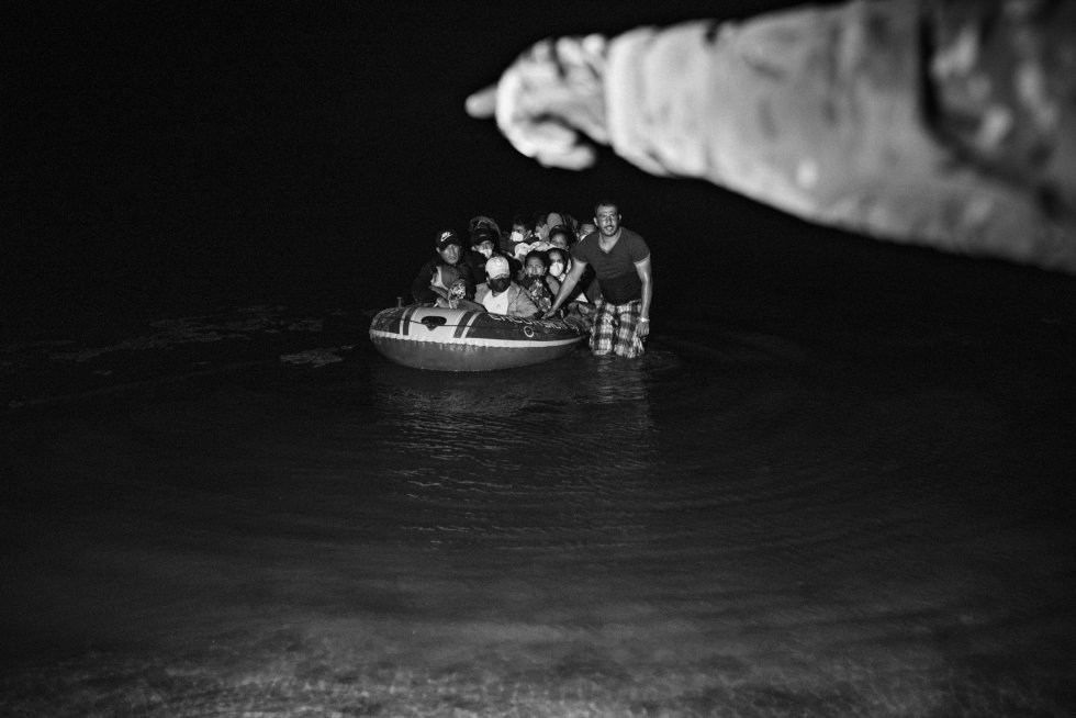 Un grupo de migrantes en el río Grande intenta cruzar la frontera en una barca mientras un soldado estadounidense les indica adónde ir.   He tenido presente la diversidad de motivos que empujan a cada población a emigrar, pero con la sensación de que las historias que contaba formaban parte de una sola narrativa, y que la condición migrante y el desplazamiento forzado caracterizan a las sociedades americanas. Algunos nunca llegan a su destino. Otros siguen moviéndose, esperando encontrar un lugar para comenzar de nuevo su vida.  rn