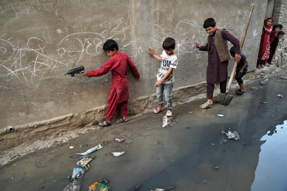 Niños tratan de pasar por una calle en la que se ha vaciado una fosa séptica en un barrio próximo a la zona de Sarai Shamali de Kabul, el 20 de septiembre. La Unión Europea estima que 18 de los 40 millones de afganos necesitan ayuda humanitaria. Uno de los dilemas de la comunidad internacional ahora es cómo ayudar a esa población sin otorgar reconocimiento ni fondos económicos a las autoridades del Emirato.
