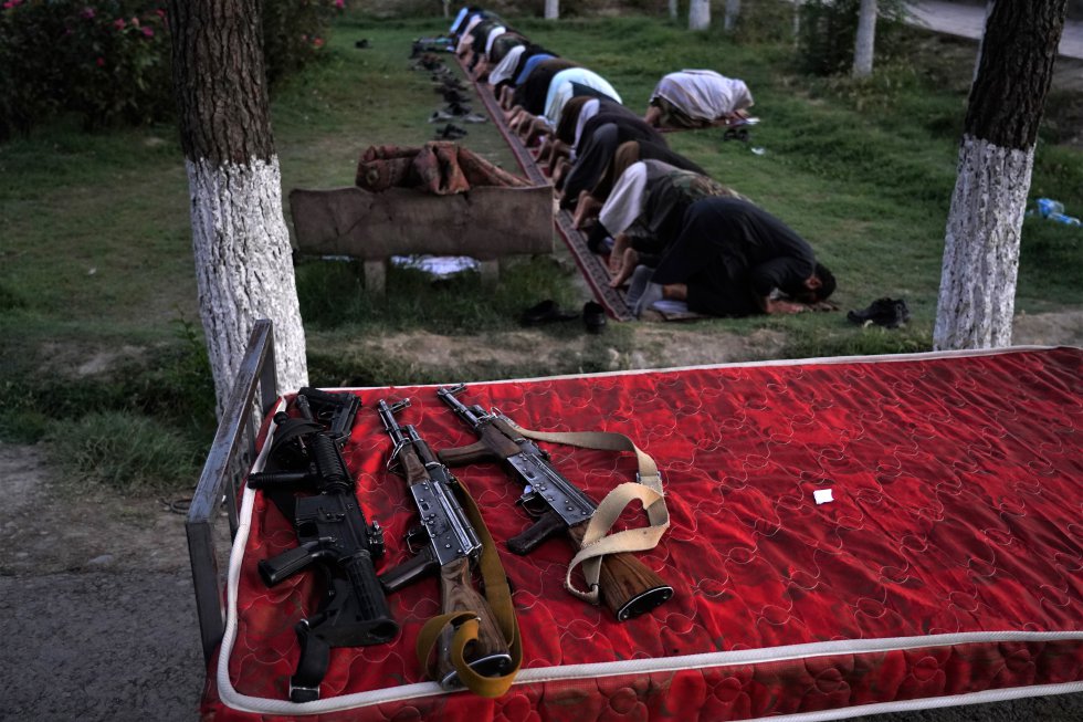Un grupo de talibanes reza al caer la tarde mientras sus armas reposan en una cama en la que pasan en día en los jardines de la colina de Wazir Akbar Khan, el 5 de octubre. Se trata de un lugar en el que hasta la instauración del Emirato ondeaba la mayor bandera del país. Hoy ha sido retirada y el acceso a las miles de familias que acudían a pasear o a comer en pic-nic tienen prohibido el acceso.