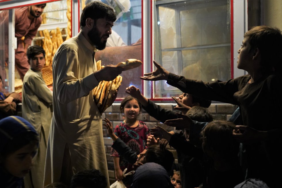 Un grupo de niños pide pan al cliente de una panadería, el 27 de septiembre. Los miles de establecimientos de este tipo en Kabul son un lugar habitual al que acuden mujeres y niños para pedir comida. Una pieza de pan cuesta unos 10 céntimos de euro y es la base de la alimentación de muchas personas.