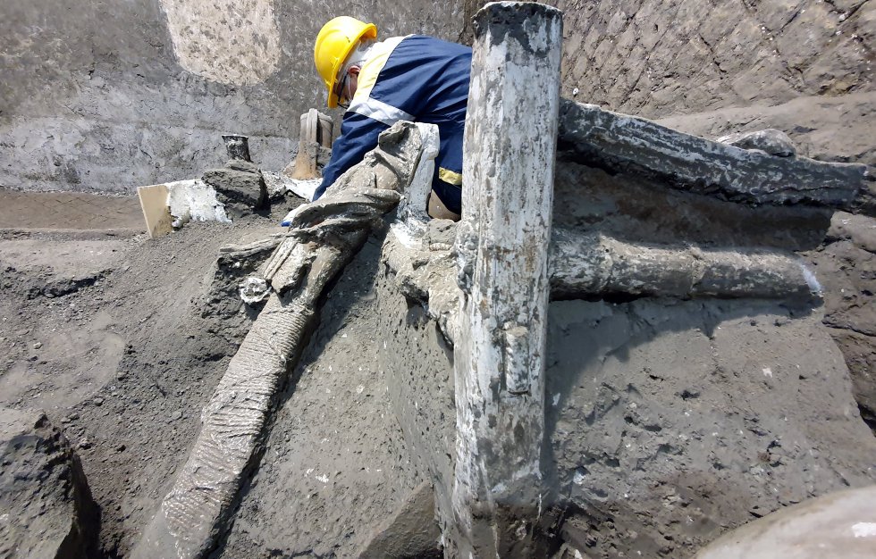 Un miembro del equipo trabaja sobre una de las camas. Gracias al refinamiento de la técnica de moldes inventada por Giuseppe Fiorelli en el siglo XIX, se han localizado tres camas y otros objetos pertenecientes a estas personas, que probablemente eran los empleados que se ocupaban del trabajo diario de una villa romana, incluida la preparación del carro de caballos.