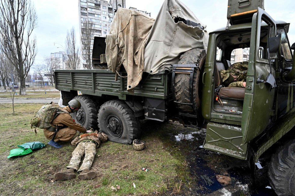 Un médico ucranio examina el cuerpo de un militar ruso, con uniforme ucranio, en la capital del país, este viernes.