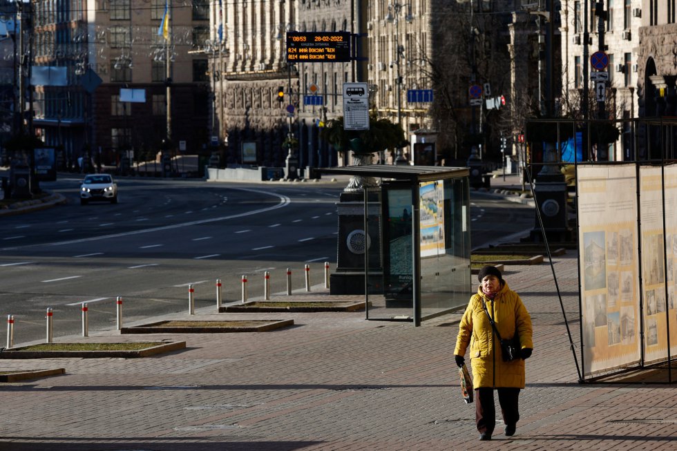Una mujer camina por una calle desierta de la capital ucrania tras finalizar el toque de queda decretado por el Gobierno de Zielinski en respuesta a la ofensiva militar rusa.