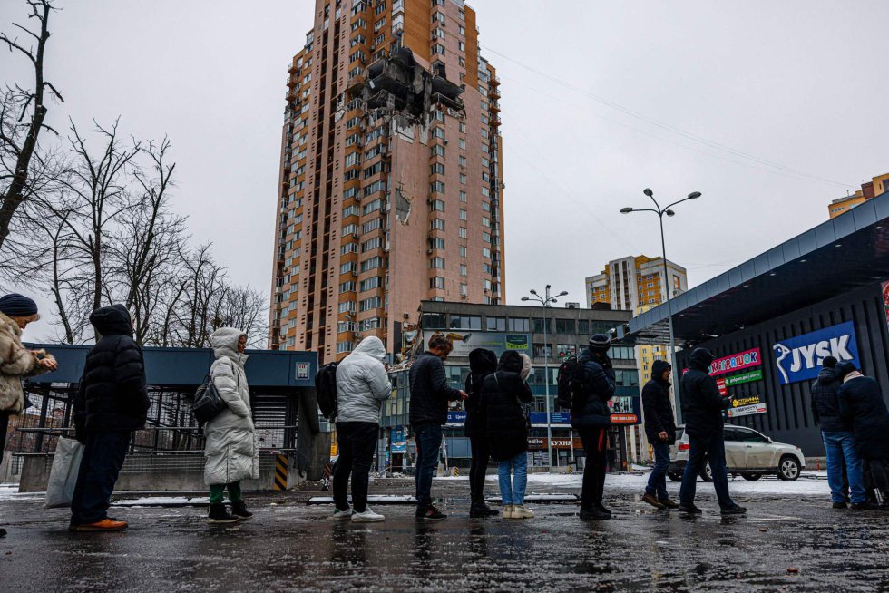 Një grup njerëzish qëndrojnë në radhë këtë të martë përpara një supermarketi në Kiev. Në sfond, një ndërtesë e dëmtuar nga një raketë e lëshuar nga ushtria ruse në ofensivën e saj në kryeqytetin ukrainas. Radhët për të marrë ushqim, riaktivizimi i pjesshëm i trafikut ose shikimi i njerëzve nga një vend në tjetrin nëpër qytet supozojnë një ringjallje të vogël të jetës së përditshme pas një fundjave letargjie të detyruar. Kryeqyteti ukrainas sapo ka dalë nga një shtetrrethimi 39-orësh që ka mbajtur popullsinë në shtëpi nga e shtuna pasdite deri të hënën në mëngjes.